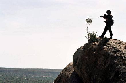 On a lone hilltop a Highlander stands