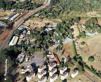 Aeiel view with camp at top,left of centre in open ground, with surrounding housing.